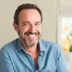 Middle-aged man with a beard smiling while wearing a blue shirt.